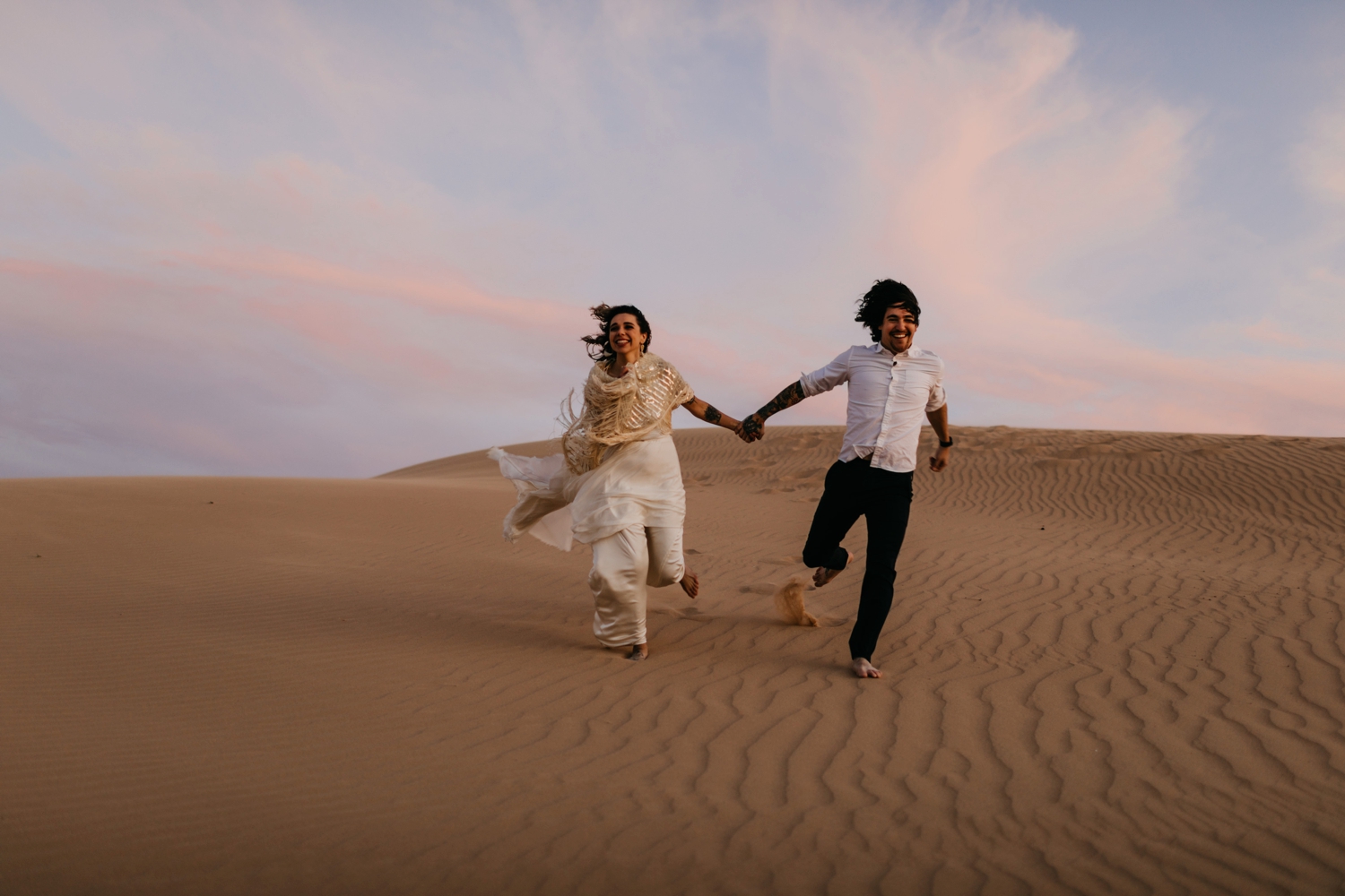 bride and groom running in desert 